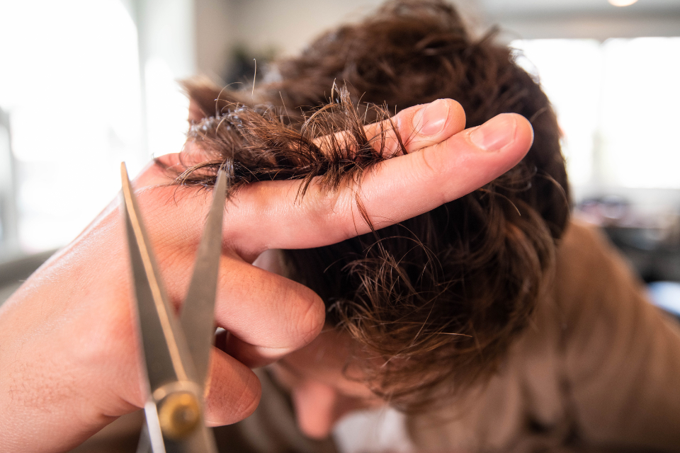 Friseurin schneidet im Salon Haarraum präzise eine Haarpartie