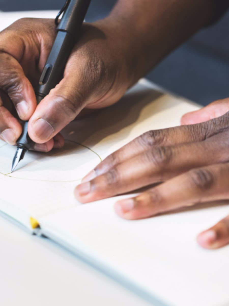 Hand skizziert mit einem Stift eine Rundung auf kariertem Papier