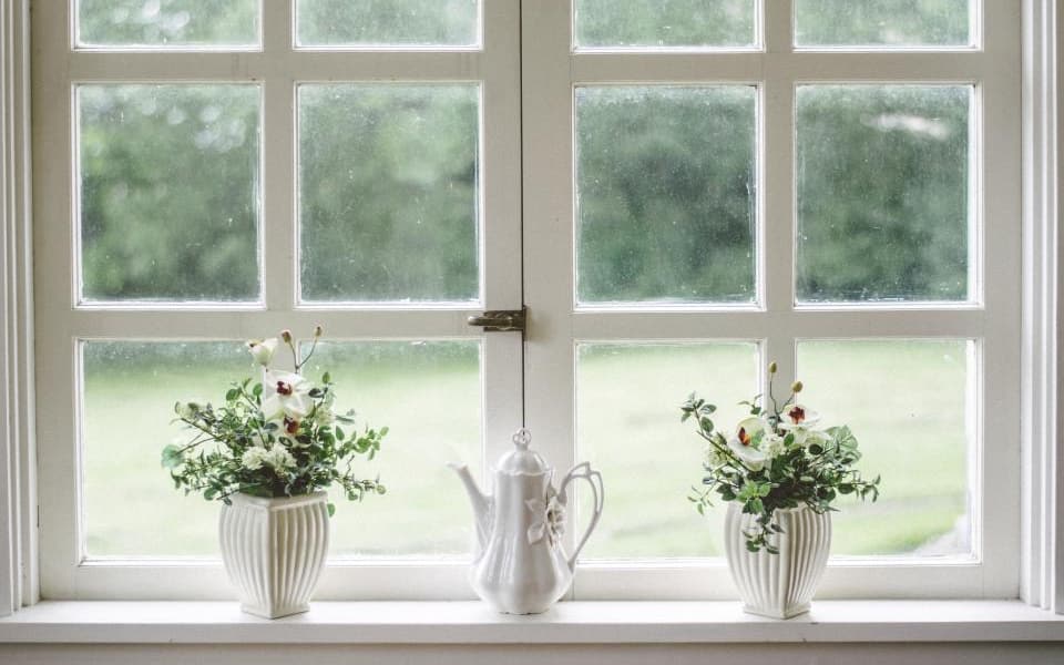 Holzfenster mit Sprossen und sichtbarem Beschlag in Nahaufnahme