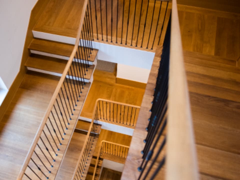 Sanierte Holztreppe mit neuen Trittstufen und schlichtem Geländer